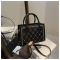 Detail of black crossbody bag featuring gold quilted heart embroidery and leather texture - Black