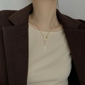 Collana a doppio strato color oro con pendenti a quadrato e barra su giacca marrone - Stile Geometrico a Incastro Quadrato e Barra / Oro