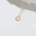 Squisita collana dorata con pendente circolare bianco e motivo a stella d'oro al centro - Stella a otto punte