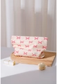 Dettaglio della borsa in cotone crema con fiocchi rosa e styling professionale da scrivania - Fiocco Rosa