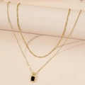 Elegante collana in titanio dorato a doppio strato con catena Figaro e ciondolo rettangolare nero - Oro