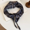 Vintage navy paisley print silk neck scarf tied in a bow on an art book surface - Blue Triangle Scarf