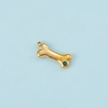 Detail shot of a golden bone pendant featuring a vibrant blue zircon stone inlay - Gold Color December