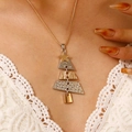 Gros plan d'un collier pendentif sapin de Noël bicolore porté sur col en dentelle - Sapin de Noël Bicolore (K-432)