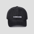Dettaglio del ricamo CONQUER bianco su cappellino da baseball in cotone nero lavato - M (56-58cm) / Nero