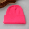 Détail du bonnet en tricot rose vif avec texture côtelée douce et bordure à revers large - Rose rouge