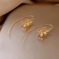 Elegant gold iris flower hook earrings with textured petals on a golden surface - Gold Iris Flower Ear Hooks