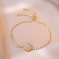 Detail of adjustable gold bracelet featuring a rotating petal charm and white zircons - Snowflake Bracelet (TS0193) / Gold