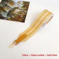 Close-up of geometric yellow and white woven wide bag strap with gold metal swivel hook - Yellow + Yellow Leather