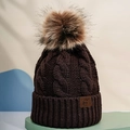 Close-up of brown knit beanie showing cable pattern, pom-pom, and leather patch - One Size / Coffee