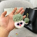 Gros plan d'un porte-clés en peluche chou-fleur avec lunettes sur un sac à main - Emballage en sac OPP unique / Blanc