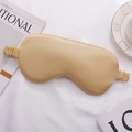 Champagne gold silk sleep mask with elastic headband on elegant white fabric - Gold