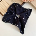 Detail of fabric heart scrunchie with white stitching on beige velvet display - Dark Blue Heart Scrunchie