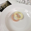 Detail of pink and yellow spiral hair ties in a decorative ceramic plate - Light Yellow + Light Brown