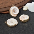 Three spiral natural shell pendants with elegant gold plated edges on grey surface - No.39 (Spiral Cut Shell - Gilded Edge)
