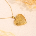 Detailaufnahme der goldenen Edelstahl-Medaillon-Halskette mit floralem Relief-Design - Gemustertes Kleines Herz / Gold
