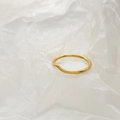 Detailed close-up of a minimalist wavy gold-toned ring on textured white paper - Thick V-Shape