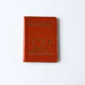 Faux leather passport holder in vibrant orange with gold heart airplane design - Vibrant Orange