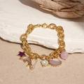 Gold chain bracelet featuring starfish and shell charms on a natural sand background - Purple Dolphin Shell Star Pendant Bracelet