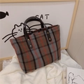 Close-up of vintage plaid tote bag featuring red and black checks with leather handles - Red Grey Plaid