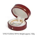 Red round PU leather jewelry box featuring a golden snake bracelet with green stones - Red Bangle Box