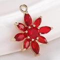 Golden flower pendant with red zircon stones on a soft white fabric background - S116-17 Gold Red Marquise Flower