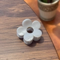 Detailed macro view of white acrylic five-petal flower hair clip with metal spring - Grey/White