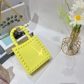 Dettaglio artistico della mini borsa gialla in PVC con borchie su riviste di moda - Giallo