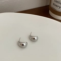 Close-up of silver water drop earrings with S925 silver needle on a white tray - Large Silver Bean