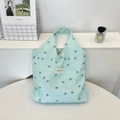 Detalle del estampado de golondrinas azules y etiqueta tejida en la textura del bolso de lona - Estilo De Bolsa Chaleco