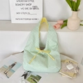 Close-up of green checkered tote bag with a yellow bow decoration and soft cotton canvas texture - Green