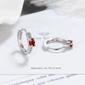 Detail of silver hoop earrings featuring oval red zircon and white diamond accents - Red Zirconia
