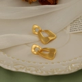Close-up of gold matte geometric hollow earrings on a white premium decorative plate - Irregular Geometric Hollow (HE1786) / Gold