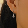 Detailed view of silver flower charm earrings with sparkling zircons worn by a model - Silver Clover Flower Pendant Ear Buckle (WG-0654)