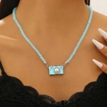 Light blue camera necklace featuring a central pearl and sparkling rhinestones - Light Blue Beaded Camera Necklace (3159)