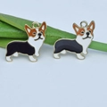 Makroaufnahme von zwei Emaille-Corgi-Anhängern auf Blättern für DIY-Schmuck - Schwarzer Corgi / Schwarz