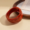 Detailed shot of dark red geometric resin bangle with vintage marble texture - Orange Amber Textured Geometric Faceted Style