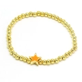 Detailed shot of golden beaded bracelet featuring a vibrant orange enamel star charm - Orange