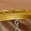 Vista dettagliata della collana con ciondolo a stella e luna riflessa in uno specchio - Pendente in Zirconia Stella e Luna Argento