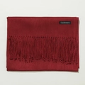 Detail shot of a red cashmere scarf featuring soft tassels and a woven material label - 70cm / Burgundy