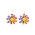 Macro detail of hand-woven daisy earrings with colorful raffia petals and gold metal hooks - Colorful