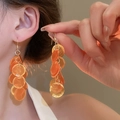 Detail of long orange shell tassel earrings with gold rings on a model's ear - Ear Hook - Coffee