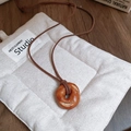 Collana a forma di croissant in pelle fatta a mano con faccina e cordino marrone - Bagel Tondo