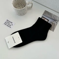 Chaussettes noires en coton respirant présentées dans un décor lifestyle minimaliste épuré - Taille unique / Noir