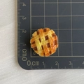 Macro view of 1.8cm miniature food resin pie with grid pattern on a measurement mat - Pineapple Bun