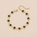 Detail van verstelbare goudkleurige stalen armband met groene hartvormige stenen - Groen