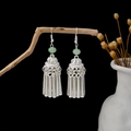 Detailed view of silver ethnic tassel earrings with turquoise beads on a wooden branch - E2542/Silver Metal Tassel