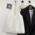 Detail view of white embroidered floral jacquard texture on minimalist canvas tote bag - Off White