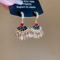 Dettaglio di orecchini a ventaglio con rubino rosso e nappe di cristallo color champagne - Stile Gancio Per Orecchio (HE28304) / Oro