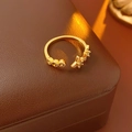 Detailed view of a gold open ring with star patterns and amber zircon stones - Ring-Green